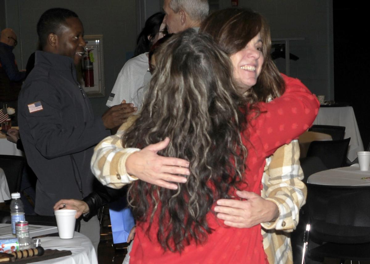 The award-winner gets a congratulatory hug from Army veteran Rebecca A. Steer, office assistant to the dean of engineering technologies.