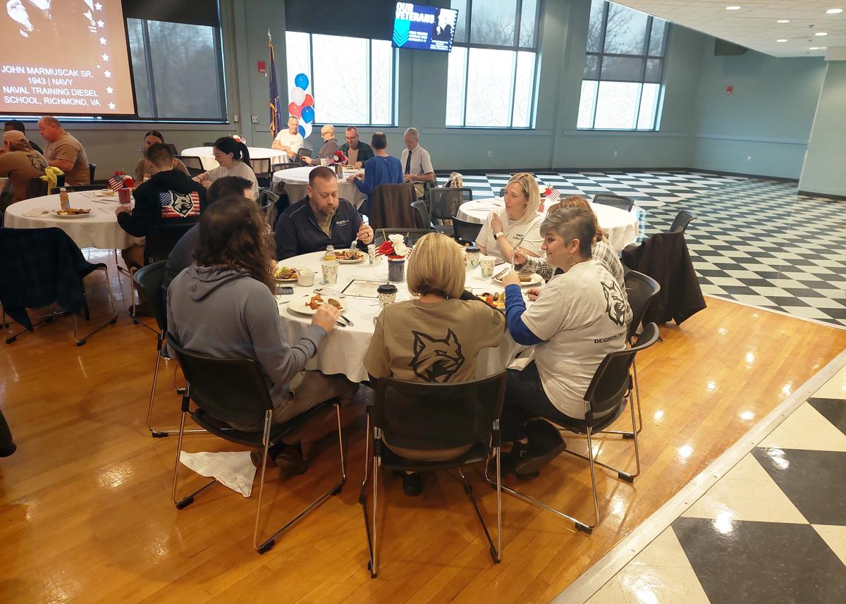 Among those wearing T-shirts to commemorate the day – olive green for veterans, light gray for allies – are (in foreground) Heather M. Shuey, senior director of employee success, who served in the Army for 12 years; and Tanya Berfield, director of student advocacy; Title IX coordinator.