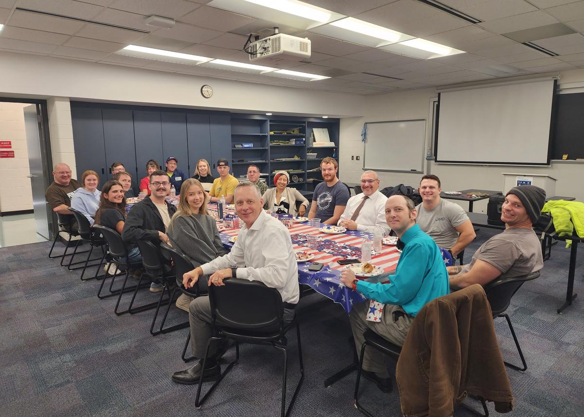 President Michael J. Reed (left foreground) joins a tribute to Penn College's military family, organized for the third year by Kimberly S. Cordrey, aviation center assistant. 