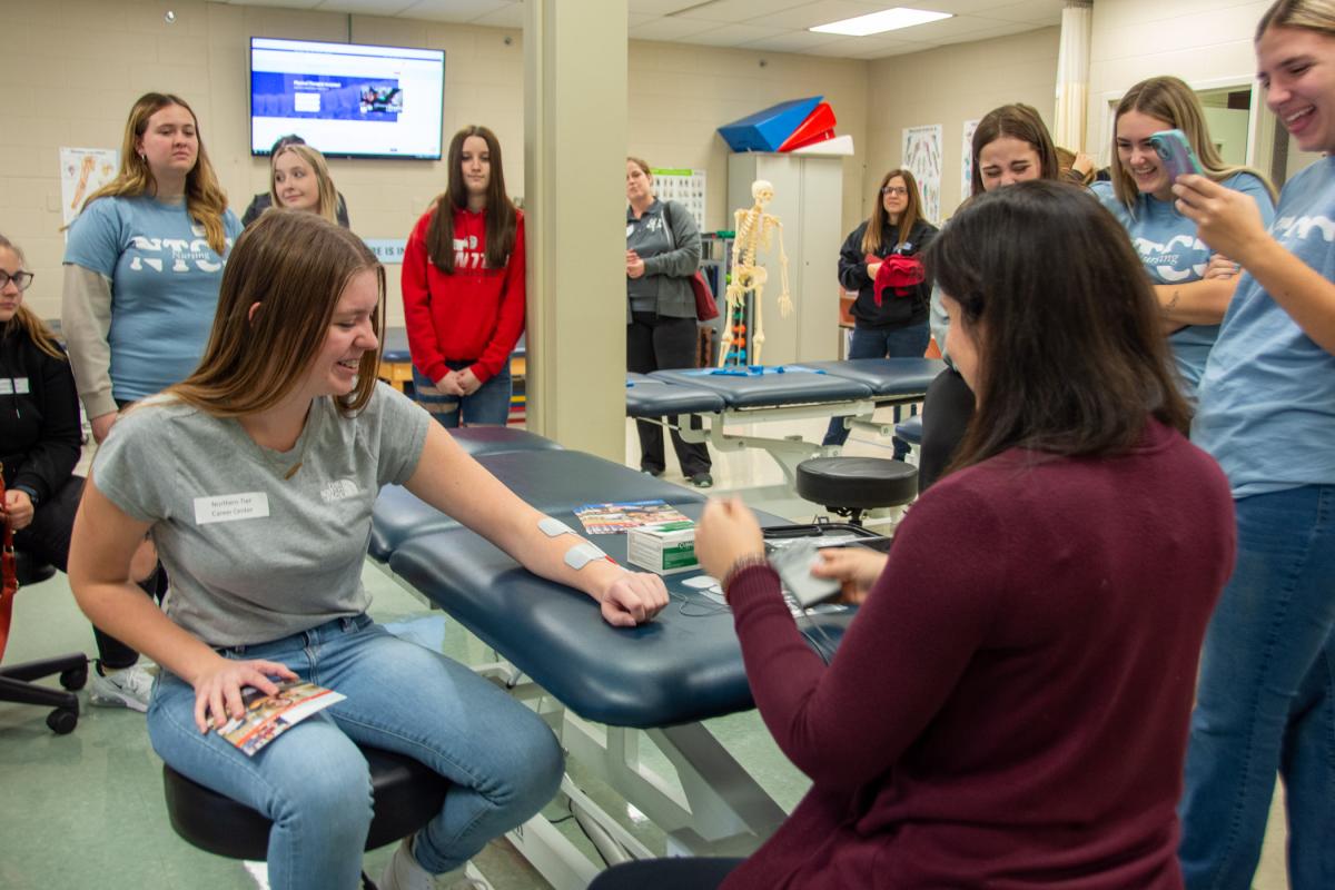 Northern Tier Career & Technical Institute students gather to watch as the unit causes classmates’ hands to move involuntarily.