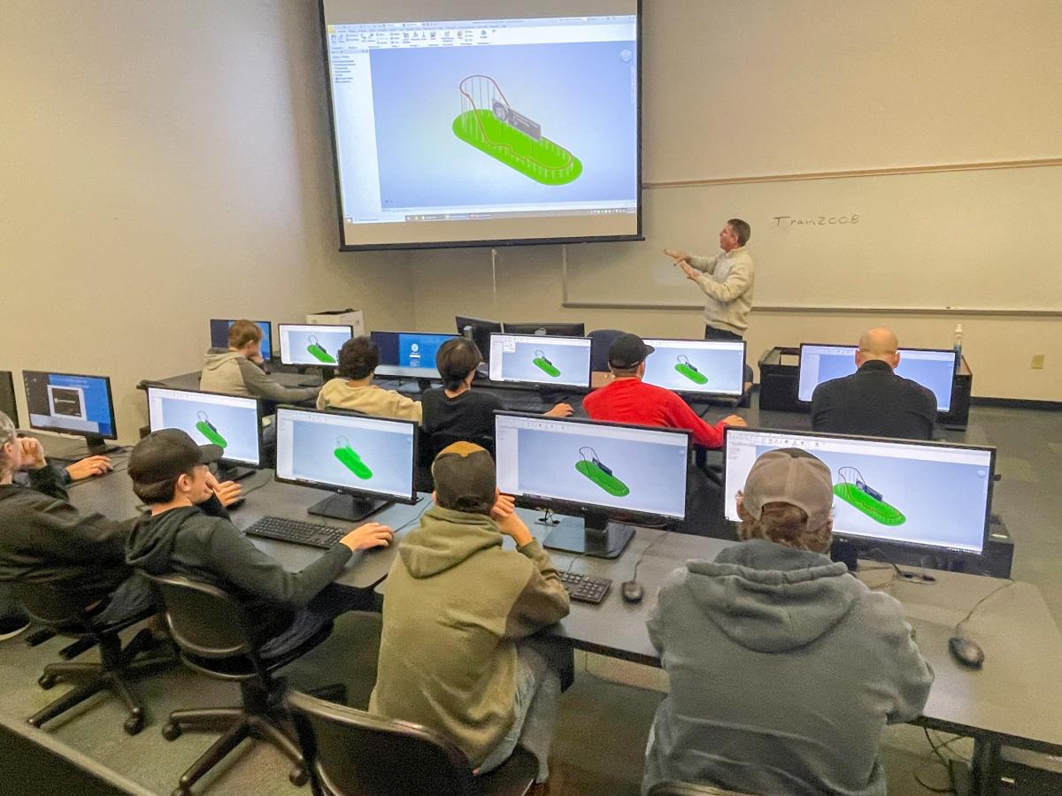 Craig A. Miller, assistant professor of engineering design technology, leads the DuBois visitors in designing a roller coaster.
