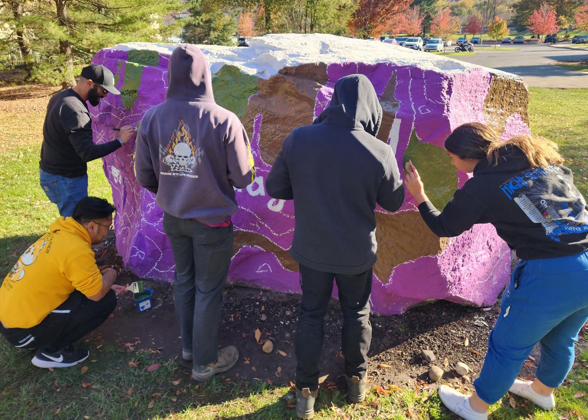 Members of the Penn College Student Veterans Organization, a chapter of Student Veterans of America, paint "The Rock" in advance of the week's observance.