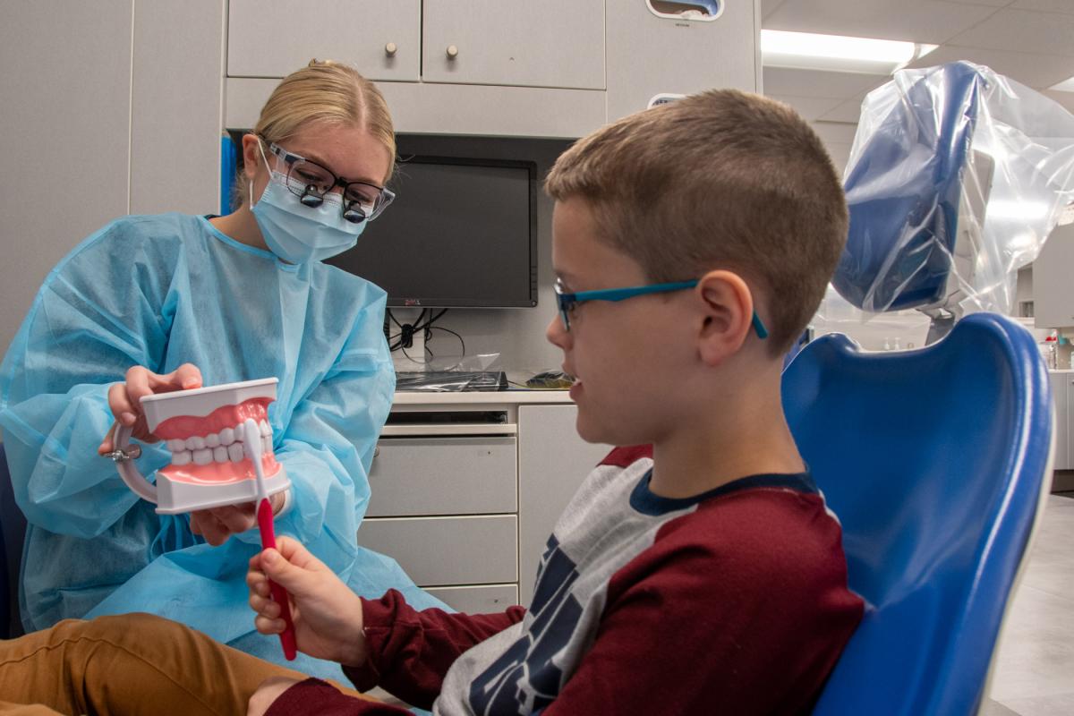 Pennsylvania College of Technology dental hygiene student Melina K. Petrick, of Falls Creek, reviews toothbrush techniques with a Sealant Saturday patient before beginning his exam. During the event, held Nov. 4 in the college’s Dental Hygiene Clinic, students and volunteers provided over $5,000 worth of free care to 22 patients. 