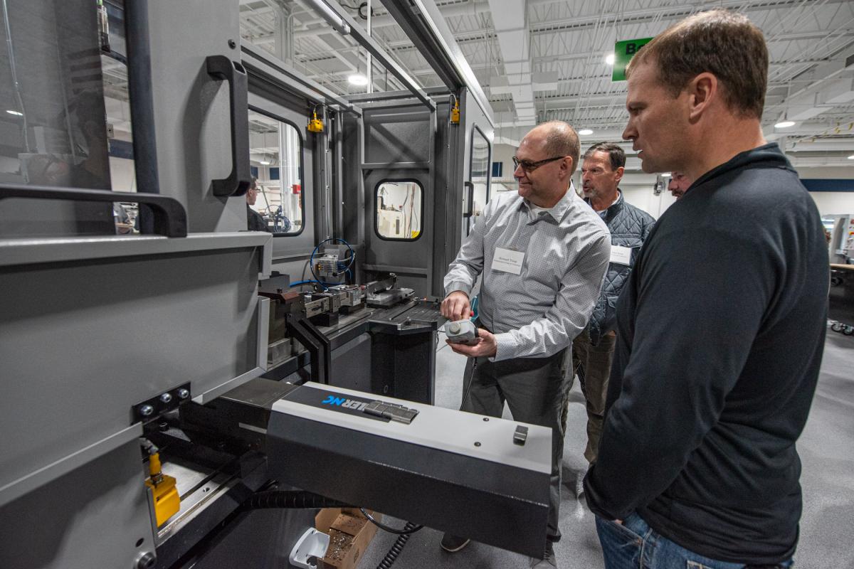 Howard W. Troup, assistant professor of automated manufacturing/machine tool design, eagerly demonstrates the Bihler 4 Slide-NC high-tech metal stamping and forming center to Jeremey Estep (foreground) and father, John Estep (background), of E-Tech Industrial Corp. The Bihler machine was recently entrusted to the college for two years by Otto Bihler Maschinenfabrik and Bihler of America Inc.