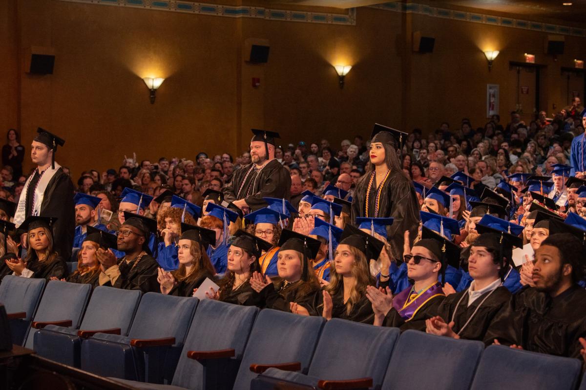 Veteran students stand for applause and recognition from the full house of graduates and guests.