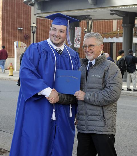 Plumbing and heating instructor Kenneth E. Welker Jr. (right) congratulates Brock W. Doyle, who earned an associate degree in heating, ventilation and air conditioning technology and a certificate in plumbing.