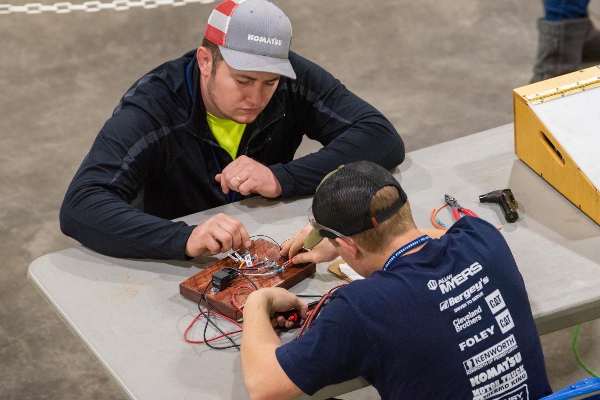 An industry volunteer engagingly evaluates a competitor's knowledge of Basic Electricity.