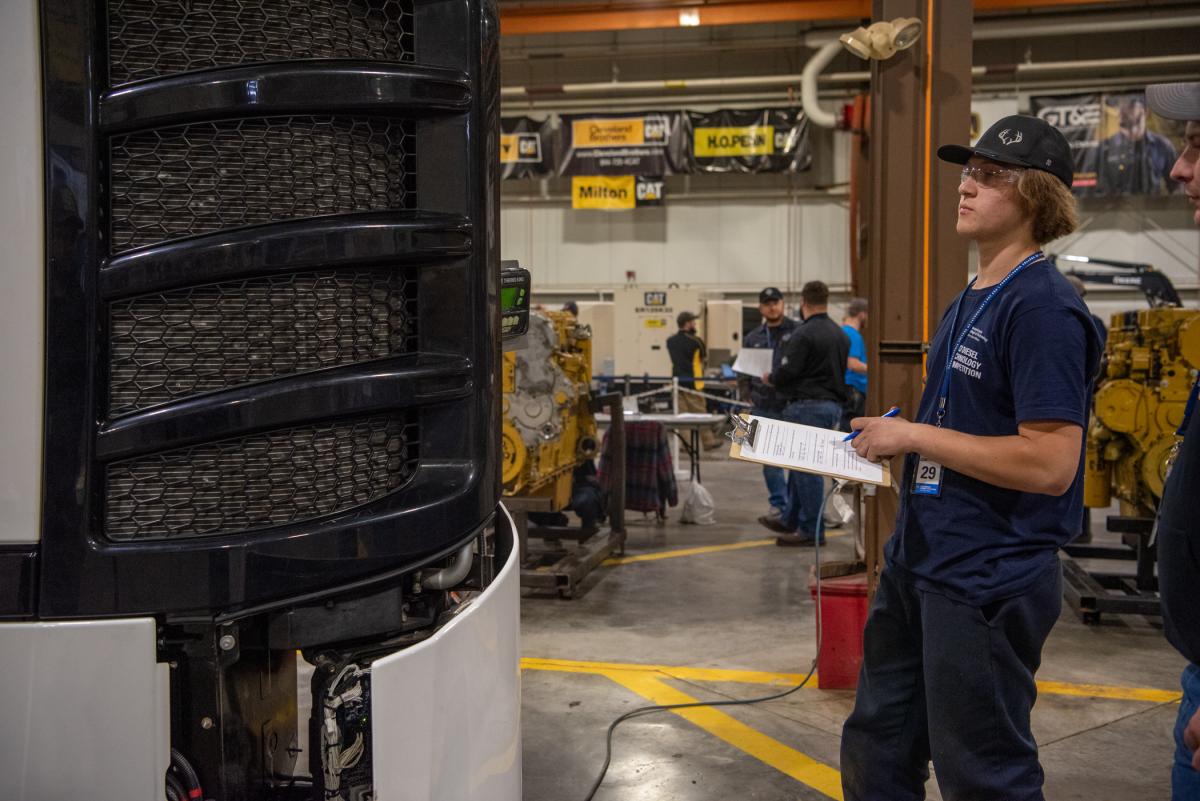 Clipboard in hand, a student confidently tackles Electrical Troubleshooting of a Mobile Refrigeration Unit.