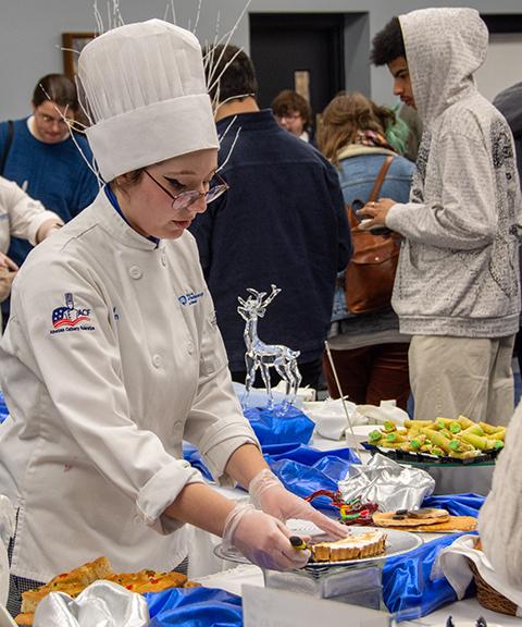 Emily Kohen, of Mill Hall, serves a piece of cranberry tart to a visiting high school student.