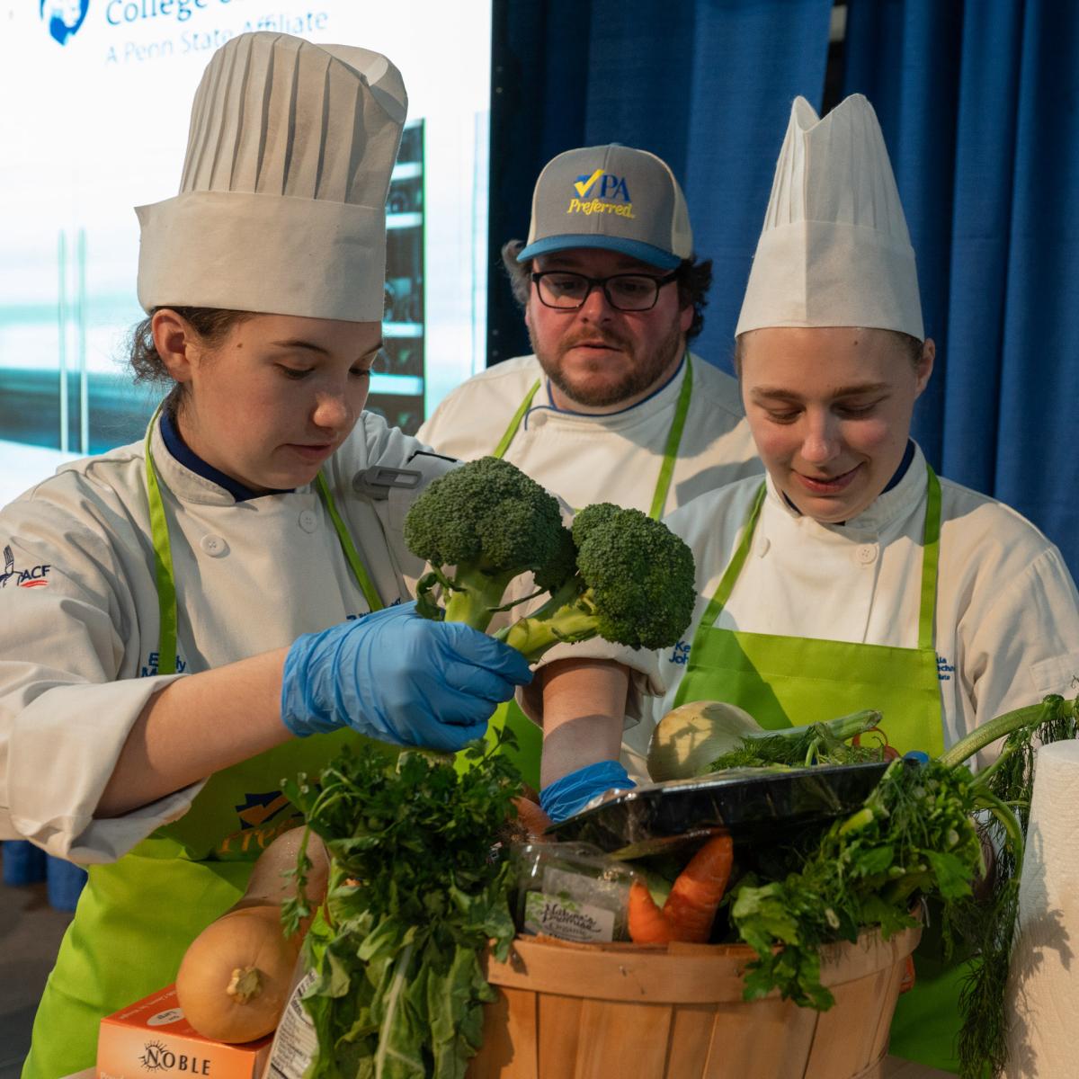 Chef Mike Dinan, executive chef of the college’s Le Jeune Chef Restaurant, looks on as students Emily Myers, of Catawissa, and Kendal L. Johnson, of Scranton, explore their basket of ingredients. Both are studying baking & pastry arts.