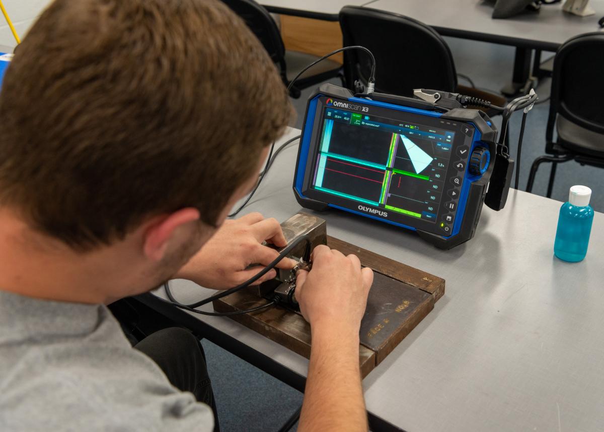 A Pennsylvania College of Technology student engages in non-destructive testing by using the phased-array ultrasonic method. Penn College offers an associate degree and competency credentials to fill the demand for NDT inspectors. In addition to phased-array ultrasonic, students receive hands-on experience in ultrasonic, radiographic, magnetic particle, liquid penetrant and visual inspection. 