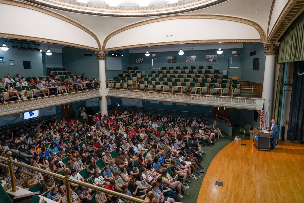 Looking down on a large audience of high school students seated in the Klump Academic Center Auditorium.