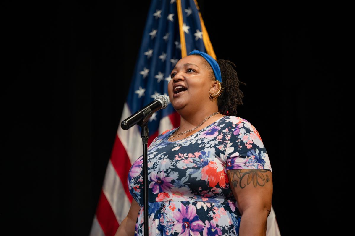 A woman sings into a microphone.