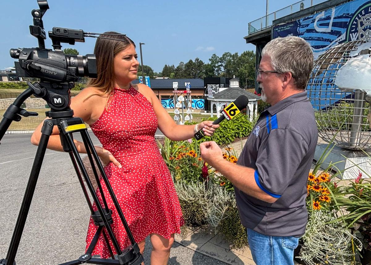 WNEP's Mackenzie Aucker stands next to camera and holds microphone up to Penn College welding faculty member Michael R. Allen.