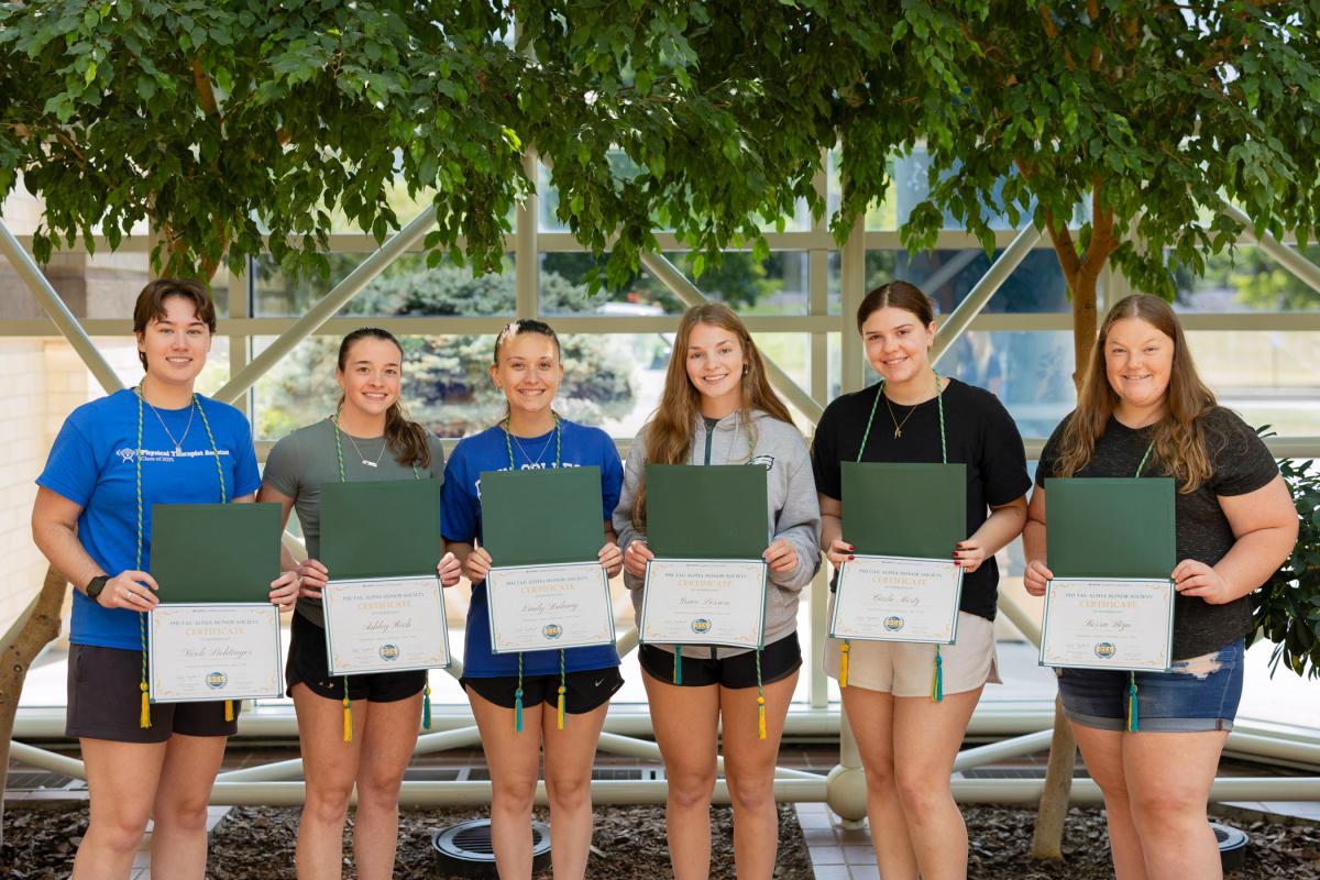 A group of students holds certificates.