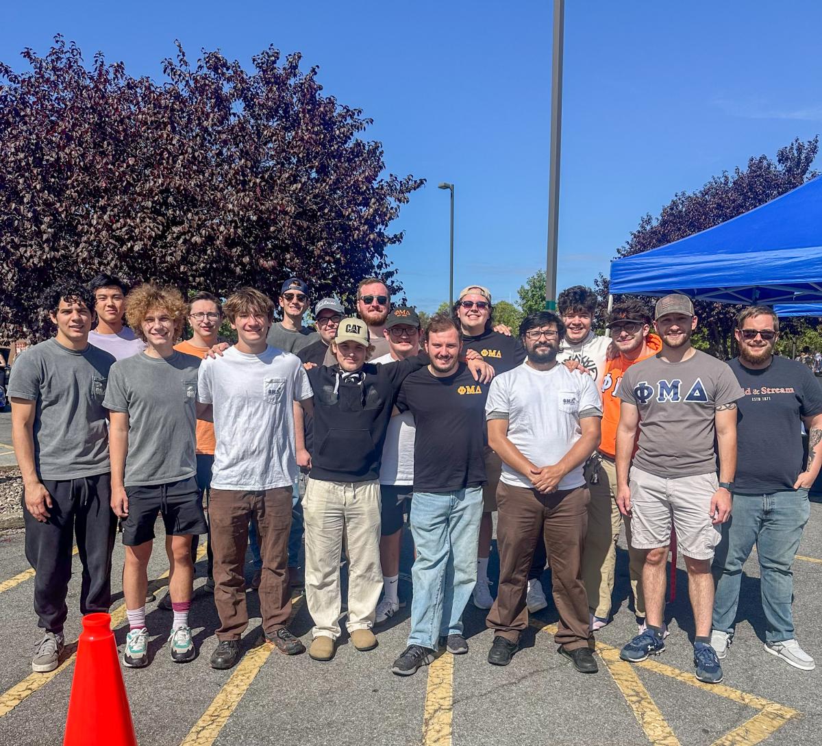 Group photo of men on a parking lot.