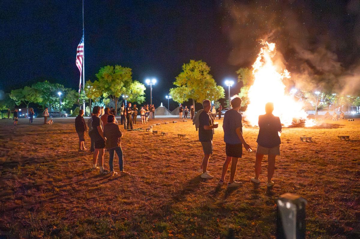 People gather around a giant bonfire on Penn College's Madigan Library lawn.