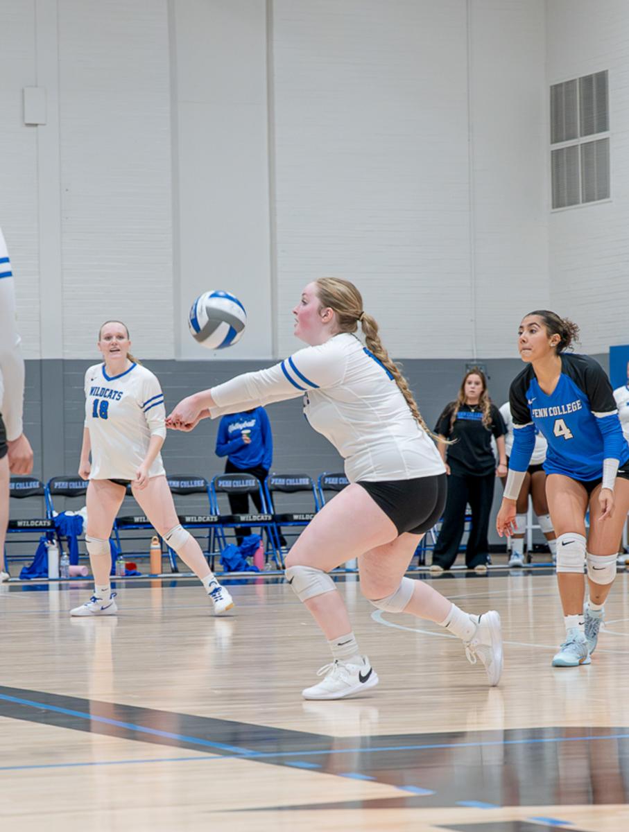 A player hits a volleyball with her forearms.