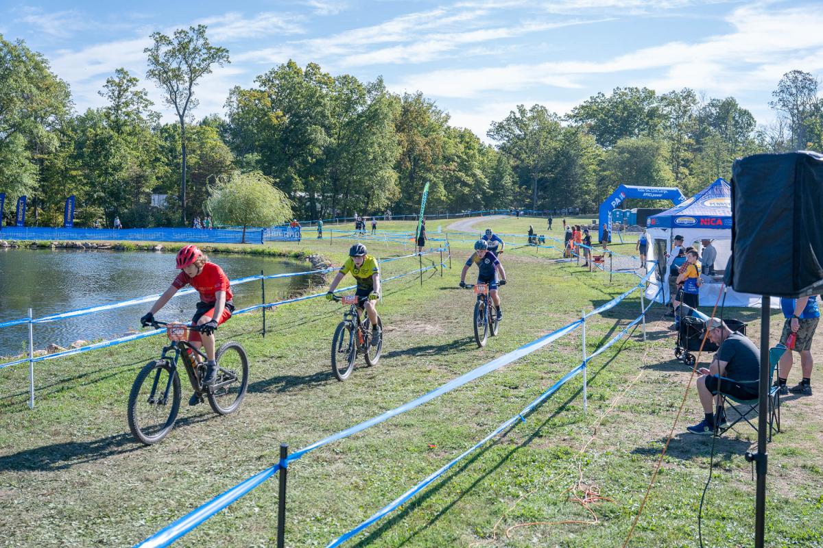 Bicyclists follow a trail around the pond at Penn College's Schneebeli Earth Science Center.