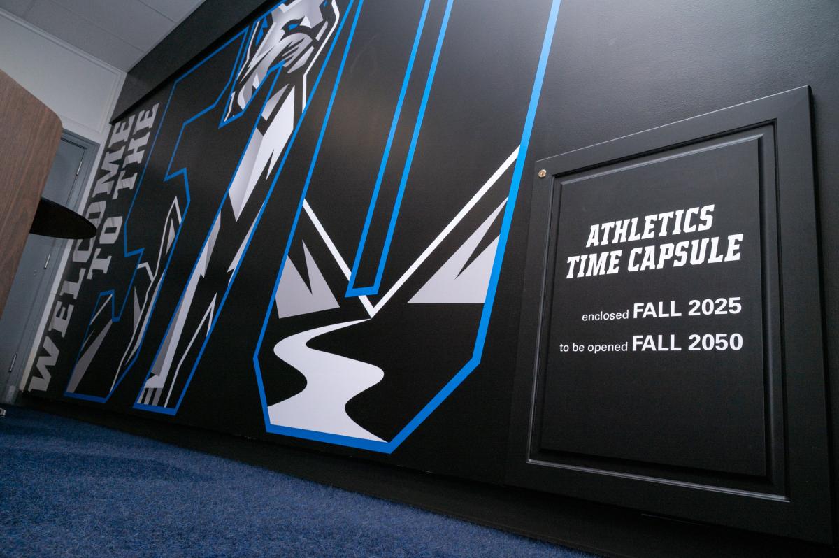 A wall in the Bardo Gymnasium lobby with a small door that reads: Athletics Time Capsule: enclosed Fall 2025, to be opened Fall 2050.