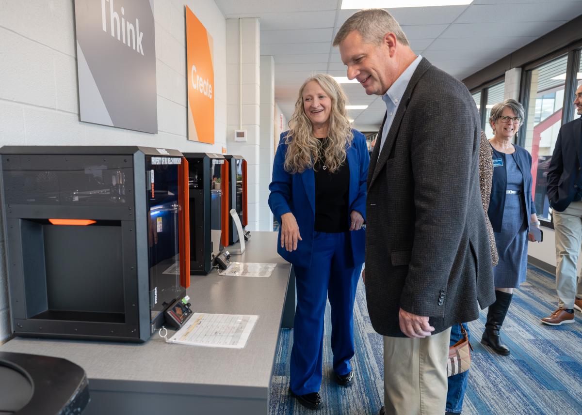 Erin Shultz and Ken Healy look at a 3D printer.