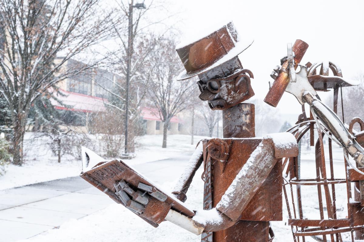 A "Student Bodies" metal sculpture topped with snow on Penn College's main campus.