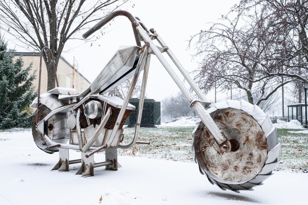 A metal sculpture of a motorcycle near Penn College's welding facilities has a coating of snow.
