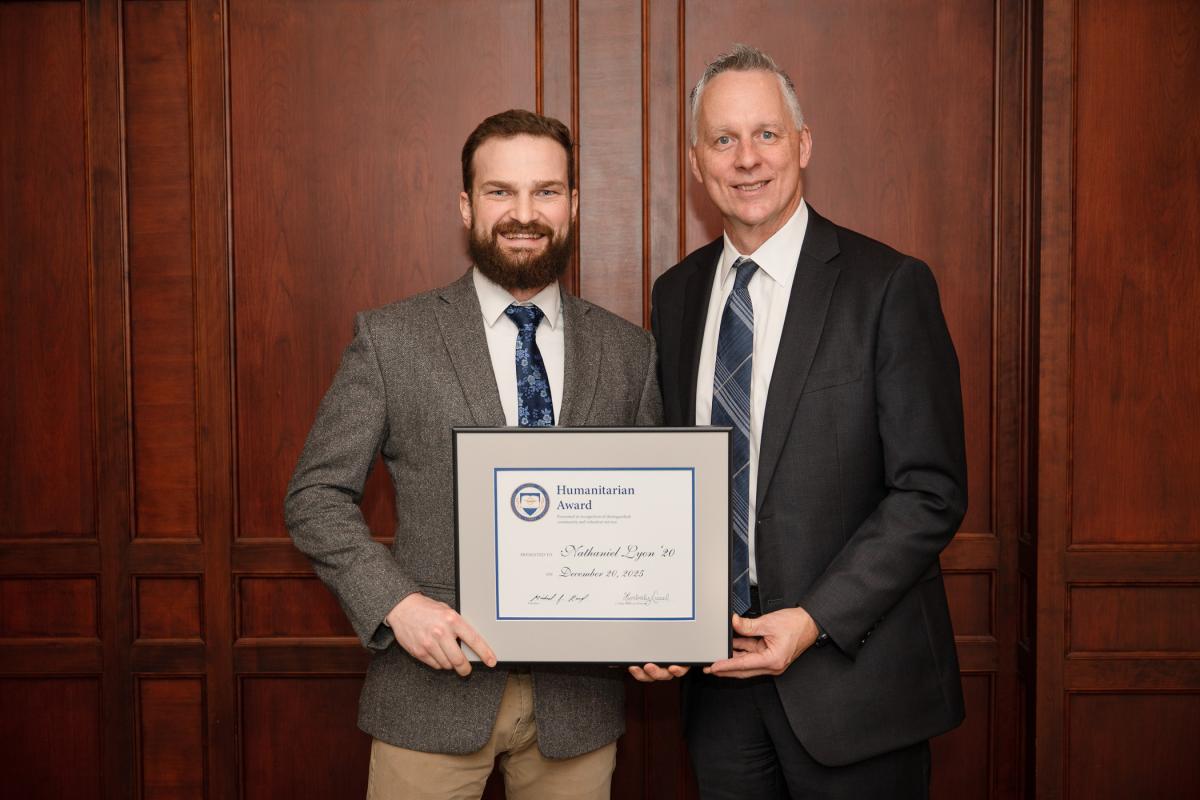 President Mike Reed congratulates Nathaniel Lyon on Alumni Humanitarian Award