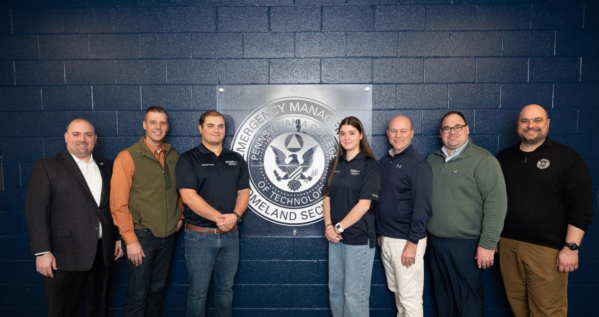 A group stands on either side of a seal that says Pennsylvania College of Technology Emergency Management & Homeland Security 
