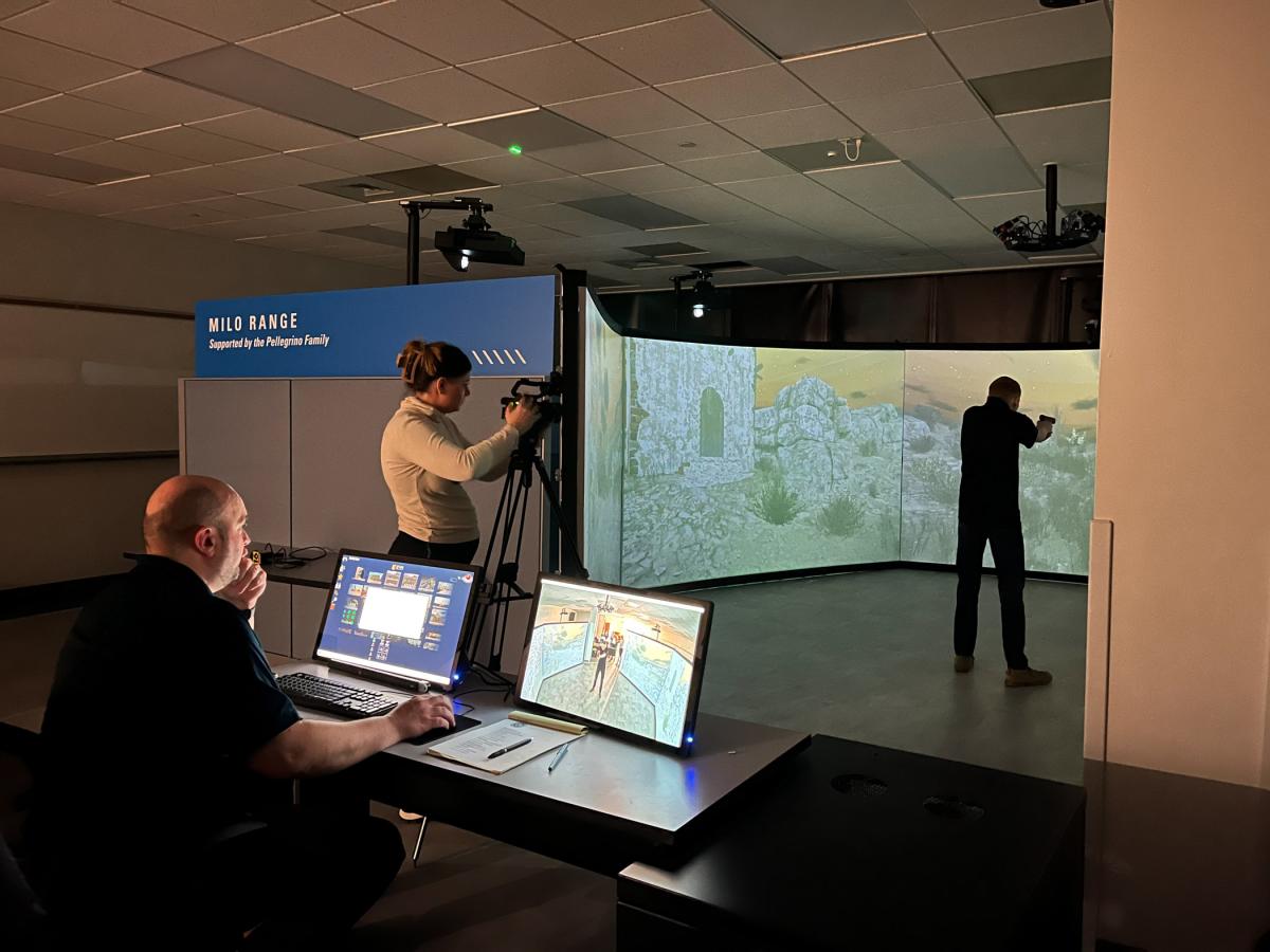 A man sits behind a set of computers, a reporter stands behind a TV camera, and a student stands surrounded by projection screens.