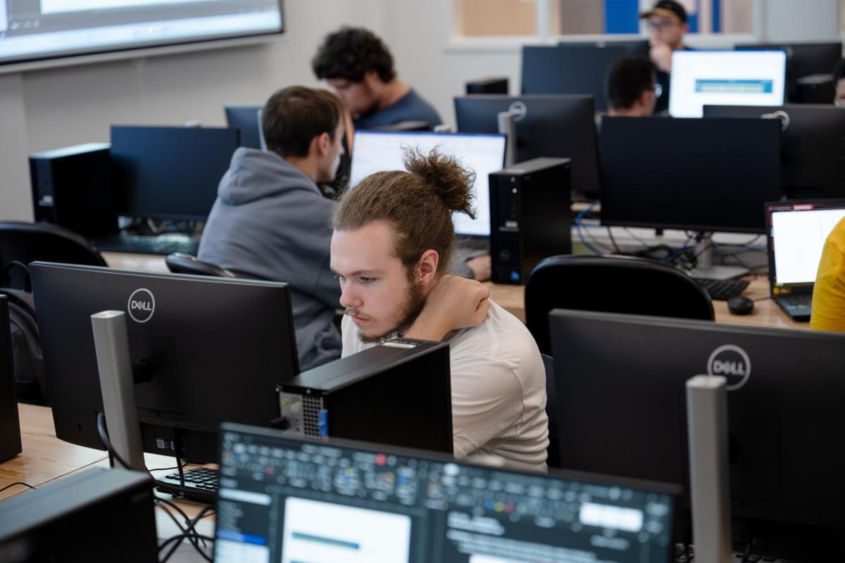 Students concentrate on monitors in a Penn College computer lab.