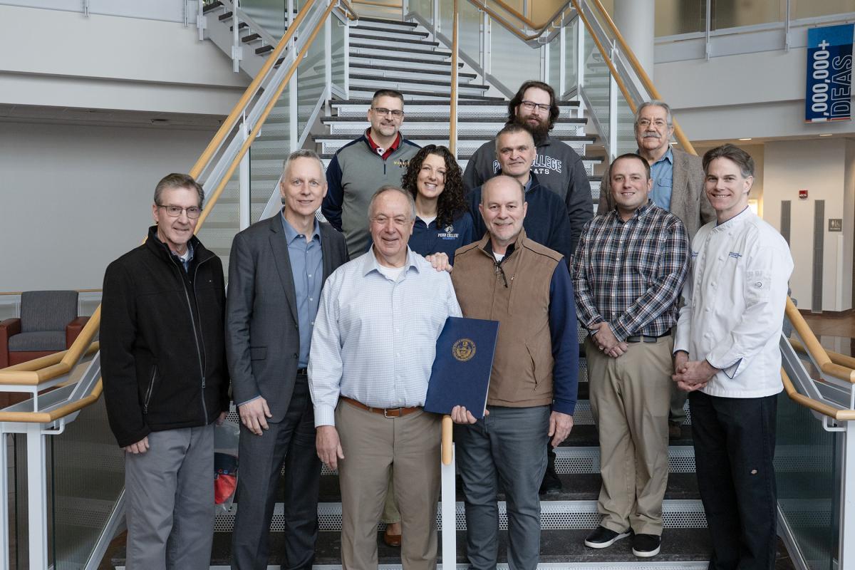 A group of people stand on stairs.