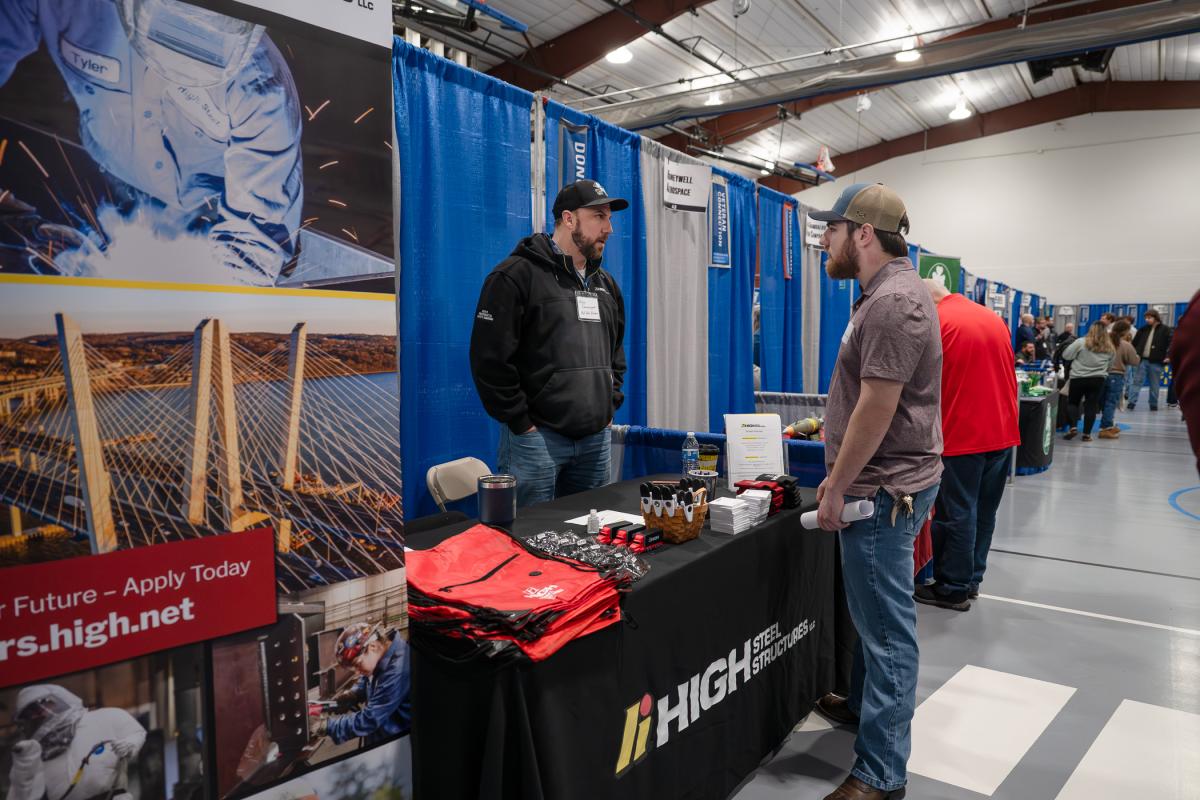 A student talks with a representative of High Steel Structures at the company's Career Fair table.
