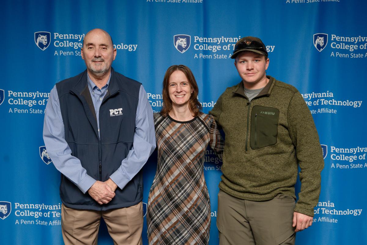 Three people stand in front of a Penn College "step-and-repeat" backdrop.