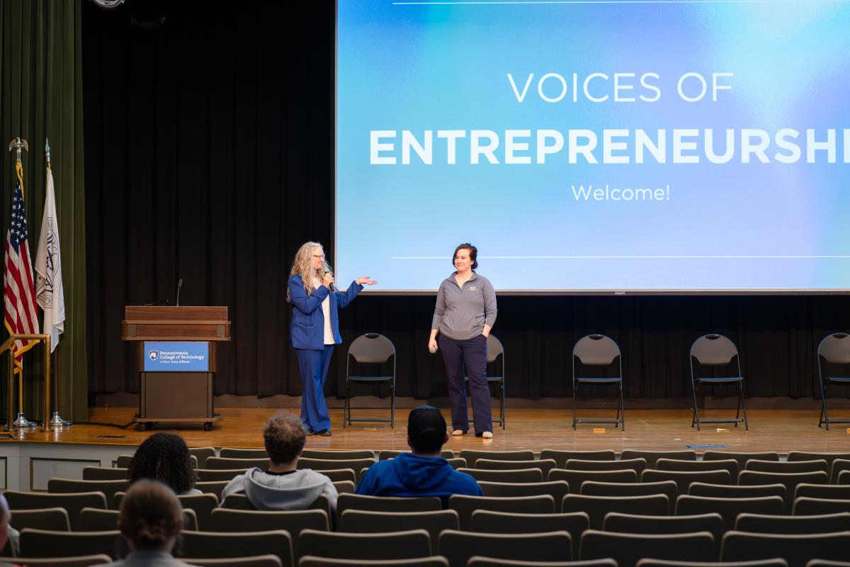 Two women appear on the Klump Academic Center stage.
