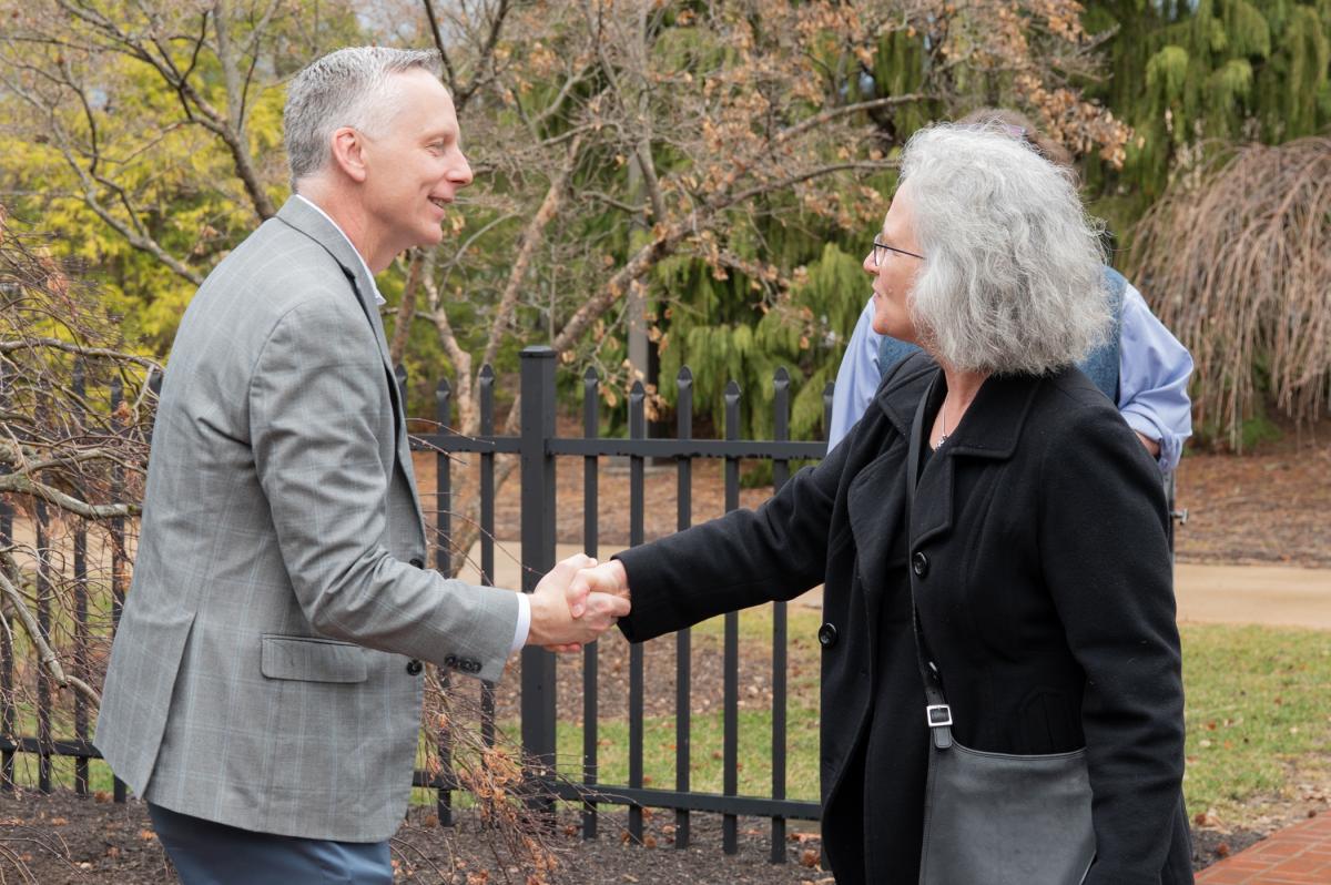 Two people in business attire shake hands.