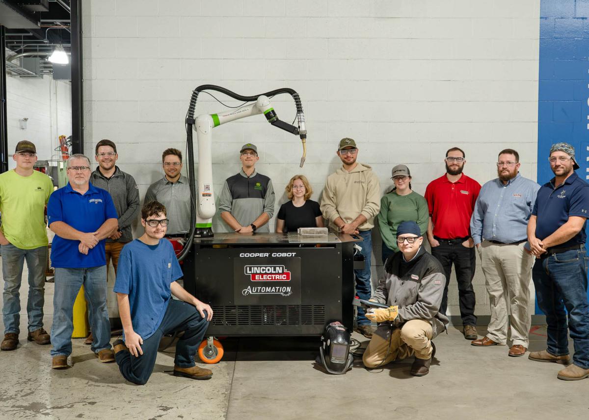 Pennsylvania College of Technology welding faculty and students and representatives from Lincoln Electric Co. surround a Cooper welding cobot.