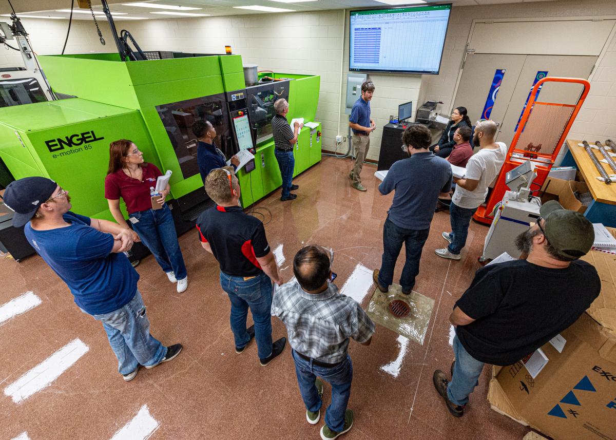 An Polymers instructor leads an in-lab training with several participants.