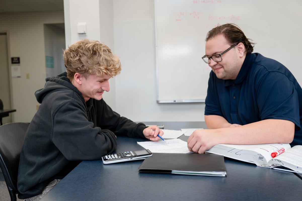 Tutor helping student with math homework.