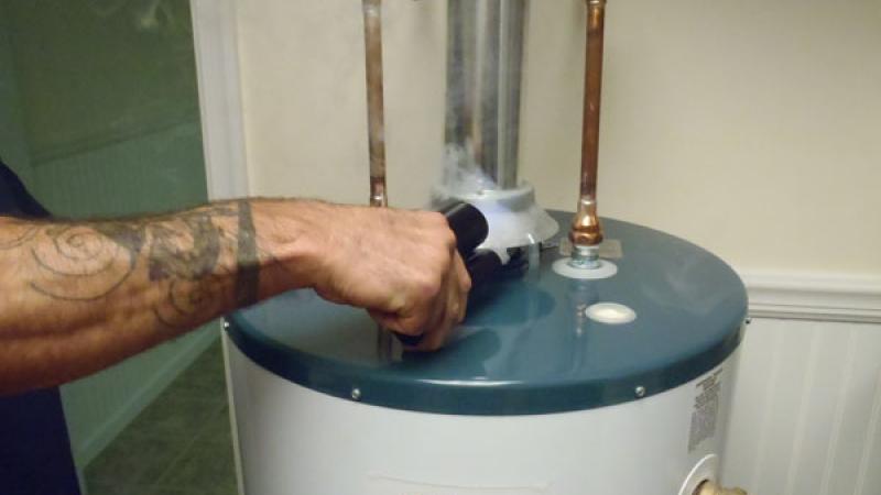 A student performs a spillage test on a domestic water heater.
