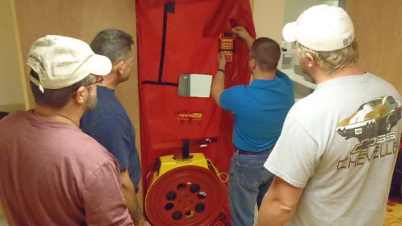 A diagnostics class learns how to use a blower door.