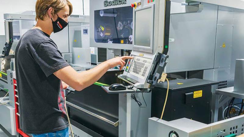 Automated manufacturing technology student Tyler J. Bandle uses one of four VL400Q High Performance Linear Motor Drive Wire Cut EDM units acquired for instructional use in the Larry A. Ward Machining Technologies Center, courtesy of a partnership with Sodick.