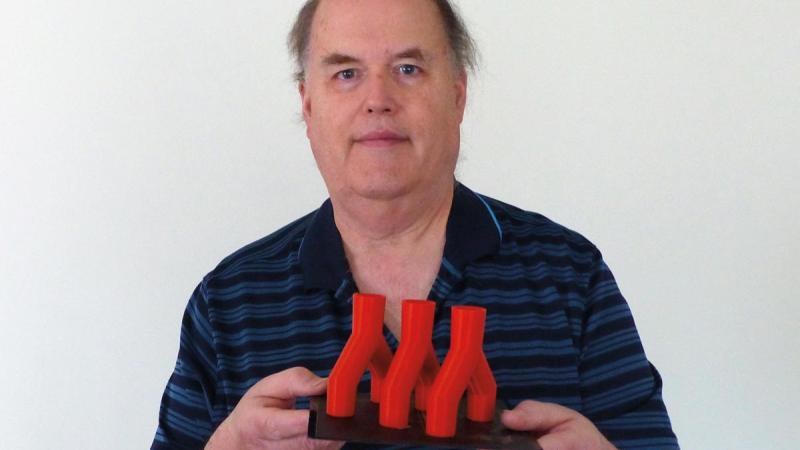 3D printing, Eric K. Albert, now retired associate professor of automated manufacturing, holds three of the eight ventilator splitters he made with his home 3D printer. On campus, he 3D-printed more than two dozen face shields.