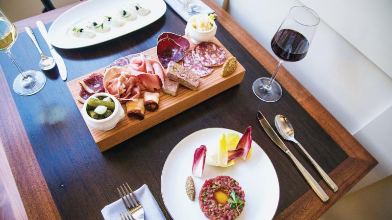 A photo-worthy spread at Perle: Fluke crudo with caviar and apple, a charcuterie board, and steak tartare