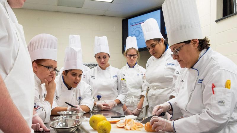Chef Mary G. Trometter, assistant professor of hospitality management/culinary arts, teaches knife skills, as she did for Diltz.