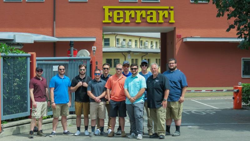 Students take advantage of a photo opportunity with an iconic Ferrari sign.