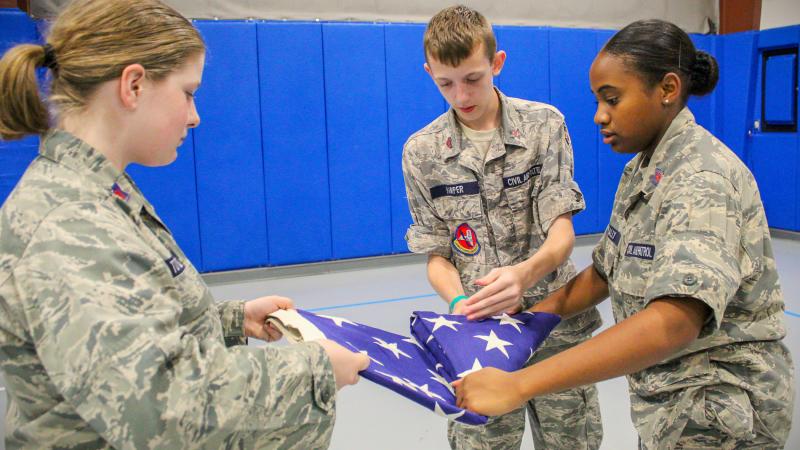A trio of cadets trains their eyes and hands on an important task: properly folding Old Glory. 