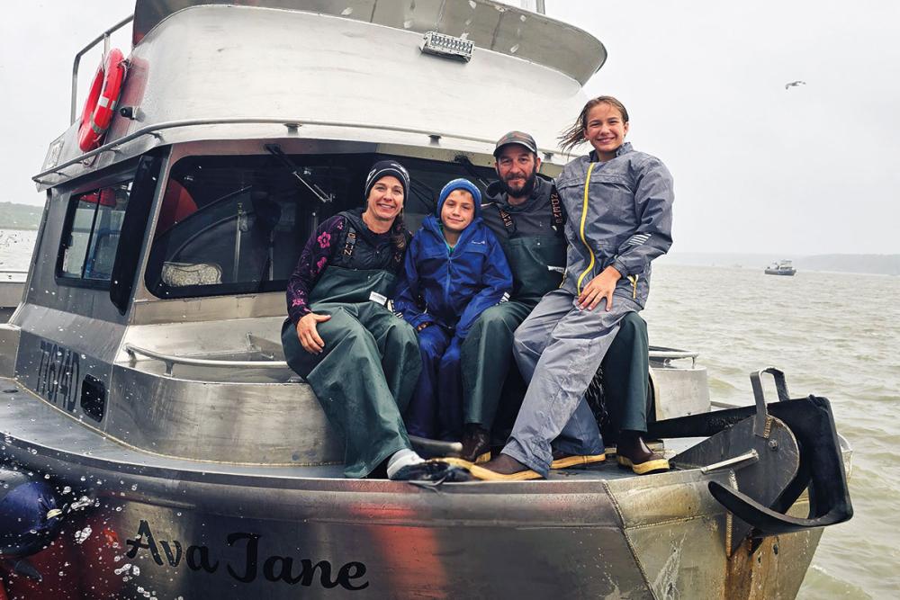 Steve Kurian ’98 (second from right), his wife, Jenn (left), and their children aboard the Ava Jane, named for their daughter. For 40 days each summer, Kurian fishes the salmon that “run” through Alaska's Bristol Bay to the rivers that flow into it. Jenn and the children join him in the final week.