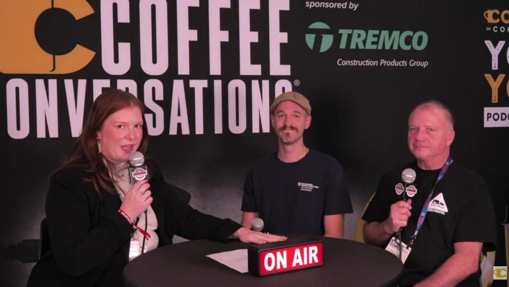 A woman with a microphone sits at a table with Penn College instructors. A small sign on the table says "On Air."