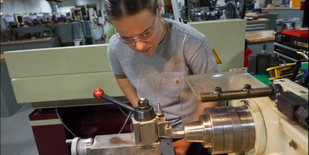 A student wearing eye protection operates a lathe in Penn College's Larry A. Ward Machining Technologies Center.